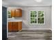 A simple kitchen has vinyl floors, wooden cabinets, natural light, and white walls at 35 Ravenwood Dr, Rockmart, GA 30153