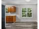A simple kitchen has vinyl floors, wooden cabinets, natural light, and white walls at 35 Ravenwood Dr, Rockmart, GA 30153