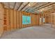 Unfinished basement with framed walls, concrete floor, and a window overlooking backyard at 7449 Waterview Cv, Douglasville, GA 30135