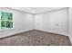 Bedroom featuring plush carpet, natural light from the window, and access to closets at 7449 Waterview Cv, Douglasville, GA 30135