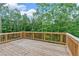 A wooden deck with a railing overlooking a lush green forest at 7449 Waterview Cv, Douglasville, GA 30135