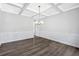 Formal dining room with coffered ceilings, wainscoting, and a stylish chandelier at 7449 Waterview Cv, Douglasville, GA 30135