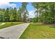 Wide concrete driveway leading to a well-manicured lawn and a two-story brick home at 7449 Waterview Cv, Douglasville, GA 30135