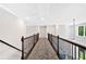Hallway with crown molding, dark railings, and carpet flooring leading to the next floor at 7449 Waterview Cv, Douglasville, GA 30135
