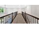 Hallway with dark railings and carpet flooring leading to the next floor at 7449 Waterview Cv, Douglasville, GA 30135
