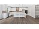 Modern kitchen with white cabinets, stainless steel appliances, an island, and hardwood floors at 7449 Waterview Cv, Douglasville, GA 30135
