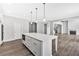 Modern kitchen featuring a large island and open floor plan leading to the living room with a fireplace at 7449 Waterview Cv, Douglasville, GA 30135