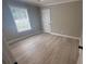 Bedroom with modern wood-look flooring, neutral walls, a window with blinds, and white trim at 1090 Coleman Sw St, Atlanta, GA 30310
