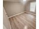 Bright bedroom with modern wood-look flooring, neutral paint, a window, and white trim at 1090 Coleman Sw St, Atlanta, GA 30310