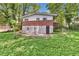 Two-story home's back exterior with brick and siding, set in a lush, green backyard at 2991 Monterey Drive Dr, Decatur, GA 30032