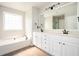 Bright bathroom with a soaking tub, a double vanity, and neutral decor at 4776 Harrod Ct, Douglasville, GA 30135