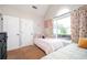 Bright bedroom featuring two beds, a large window with floral curtains, and neutral walls at 4776 Harrod Ct, Douglasville, GA 30135