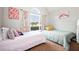 Well-lit bedroom showcasing two beds, complemented by colorful decor and a large window at 4776 Harrod Ct, Douglasville, GA 30135