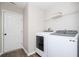 Functional laundry room with modern washer and dryer, and convenient shelving at 4776 Harrod Ct, Douglasville, GA 30135