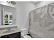 Clean bathroom featuring a shower with patterned curtain and a neutral vanity at 611 Sugar Prairie Bnd, Lawrenceville, GA 30045