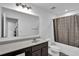 Well-lit bathroom with a shower/tub combination and a dark wood vanity at 611 Sugar Prairie Bnd, Lawrenceville, GA 30045