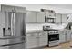 Modern kitchen features gray cabinets, granite countertops, and stainless steel appliances at 611 Sugar Prairie Bnd, Lawrenceville, GA 30045