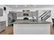 Modern kitchen features gray cabinets, granite countertops, stainless steel appliances, and a large center island at 611 Sugar Prairie Bnd, Lawrenceville, GA 30045