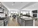 Modern kitchen with gray cabinets, stainless appliances, granite counters, and open layout to living room at 611 Sugar Prairie Bnd, Lawrenceville, GA 30045