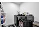 Efficient laundry room featuring a modern washer and dryer with organized shelving for storage at 611 Sugar Prairie Bnd, Lawrenceville, GA 30045