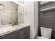 Modern bathroom featuring a gray vanity with marble countertop and decorative shiplap accent wall at 1095 Northpoint Trce, Roswell, GA 30076