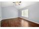 Bright bedroom boasts hardwood floors, a ceiling fan, and natural light from a large window at 1095 Northpoint Trce, Roswell, GA 30076