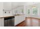 Open concept kitchen with stainless steel dishwasher, white cabinetry, and hardwood floors at 1095 Northpoint Trce, Roswell, GA 30076