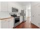 Well-lit kitchen with stainless steel appliances, white cabinets, and hardwood floors at 1095 Northpoint Trce, Roswell, GA 30076