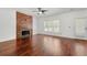 Modern living room with a unique wood-paneled fireplace, ceiling fan, hardwood floors, and natural light at 1095 Northpoint Trce, Roswell, GA 30076