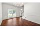 Bright living room with hardwood floors, large window, and staircase at 1095 Northpoint Trce, Roswell, GA 30076