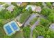 Aerial view of a community featuring homes, a pool, and tennis courts surrounded by lush greenery at 15 Vickwood Court Ne, Marietta, GA 30068