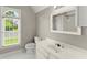 Bright bathroom with white vanity, toilet, and view of the yard from the window at 15 Vickwood Court Ne, Marietta, GA 30068