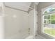 Bathroom featuring white tiled shower and window at 15 Vickwood Court Ne, Marietta, GA 30068
