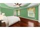 Bright bedroom with soft green walls, tray ceiling, ceiling fan and pristine hardwood floors at 15 Vickwood Court Ne, Marietta, GA 30068