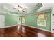 Spacious bedroom featuring hardwood floors, tray ceilings with fan, and natural light from draped windows at 15 Vickwood Court Ne, Marietta, GA 30068