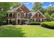 Stately brick two-story home with lush landscaping and manicured lawn at 15 Vickwood Court Ne, Marietta, GA 30068