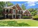Stately brick home with lush landscaping, a manicured lawn, and mature trees at 15 Vickwood Court Ne, Marietta, GA 30068