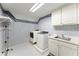Functional laundry room with a sink, washer, dryer, and patterned wallpaper at 15 Vickwood Court Ne, Marietta, GA 30068