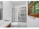 Bright bathroom with tub-shower combo, white tile, and frosted glass sliding doors to allow in natural light at 2775 Doaks Run Ct, Tucker, GA 30084