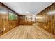 Spacious living room featuring wood paneled walls, wood floors, and large window at 2775 Doaks Run Ct, Tucker, GA 30084