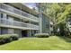 Green condo building with a lawn, three stories, white railings, and some surrounding trees at 4604 Vinings Central Se Run # 131, Atlanta, GA 30339
