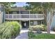 Inviting two-story condo featuring green siding, white railings, and a beautifully landscaped walkway leading to the entrance at 4604 Vinings Central Se Run # 131, Atlanta, GA 30339