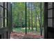A backyard and woods are seen through black framed doors at 772 Brookwood Sw Ter, Lilburn, GA 30047