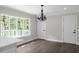 Bright dining area with wood floors, large windows, and a modern chandelier at 772 Brookwood Sw Ter, Lilburn, GA 30047