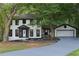 Charming two-story home featuring a well-manicured lawn, attached garage, and inviting front entrance at 772 Brookwood Sw Ter, Lilburn, GA 30047