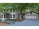 Charming two-story home with white siding, black trim, manicured landscaping, and attached two-car garage at 772 Brookwood Sw Ter, Lilburn, GA 30047