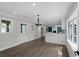 Bright kitchen with hardwood floors, white cabinets, modern lighting, and seamless flow into the dining area at 772 Brookwood Sw Ter, Lilburn, GA 30047