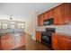 Charming kitchen boasting granite countertops, wooden cabinets, and a suite of appliances at 1768 Oakbrook Nw Ln # 9, Kennesaw, GA 30152