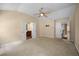 Spacious main bedroom showcasing a ceiling fan, carpet flooring and bathroom suite entry at 1768 Oakbrook Nw Ln # 9, Kennesaw, GA 30152