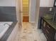 Modern bathroom with marble floors, vessel sink, and a view to an adjacent dressing room at 4125 Fastnet Lane, Duluth, GA 30096